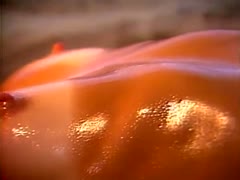 A lustful massage therapist covers her client's nude body with oil.